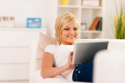 Happy woman using digital tablet at home