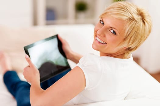 Beautiful blonde woman holding digital tablet in hands
