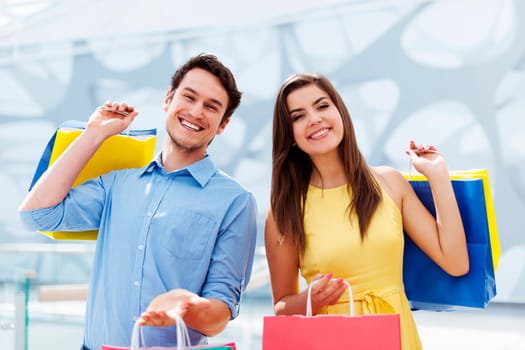 Happy young couple holding shopping bag