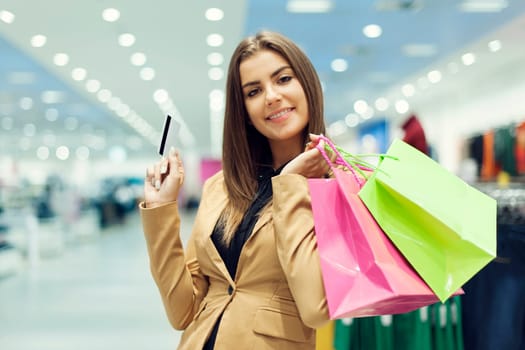 Young woman with credit card and shopping bag