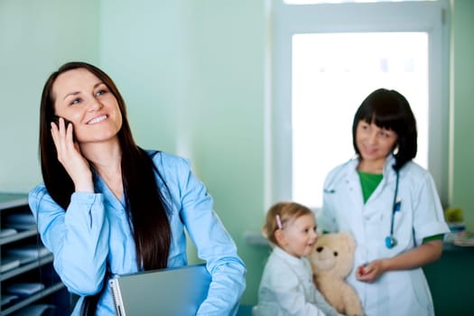 Busy businesswoman taking her daughter to the doctor