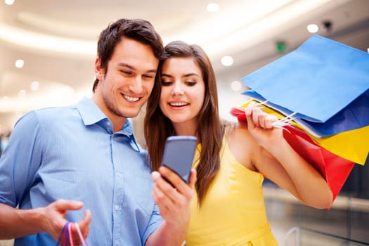 Smiling couple checking something on the mobile phone