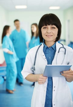 Portrait of female doctor with interns in background