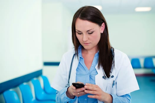 Young female doctor texting