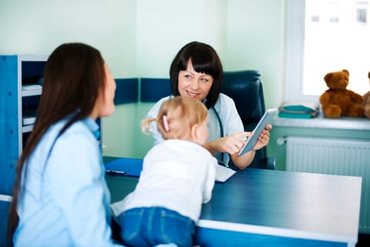 Doctor showing mother's medical results on the tablet