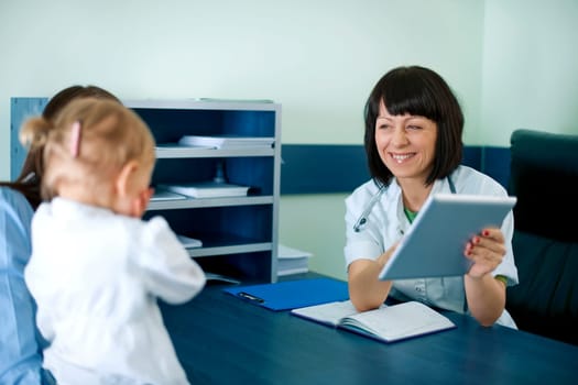 Doctor showing mother's medical results on the tablet