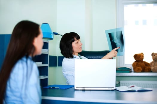 Young woman and doctor watching x-ray