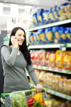 Beautiful woman on mobile phone at supermarket