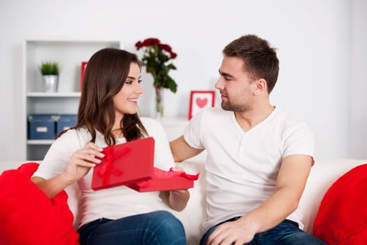 Smiling woman opening a valentine's gift