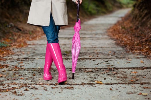 Woman with umbrella wearing rubber boots