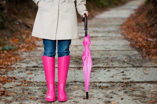 Woman with umbrella wearing rubber boots
