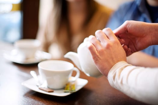 Waitress pouring cup of coffee/tea