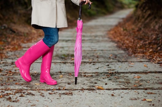 Woman with umbrella wearing rubber boots