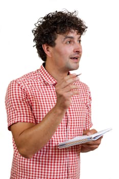 Young man happy to find a solution, holding a pencil and notebook, isolated on white background