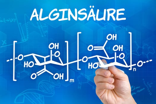 Hand with pen draws chemical structural formula of alginic acid