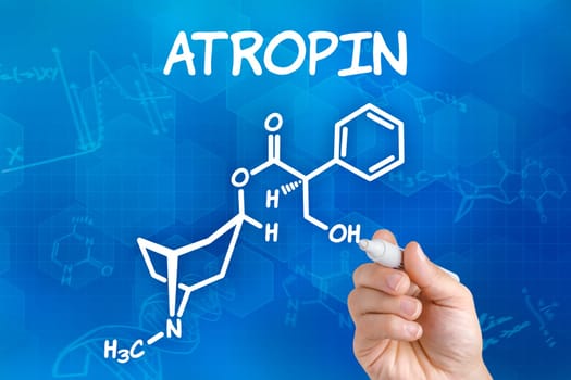 Hand with pen draws chemical structural formula of atropine
