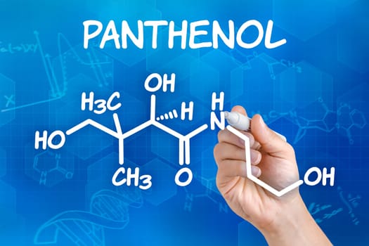 Hand with pen draws chemical structural formula of panthenol