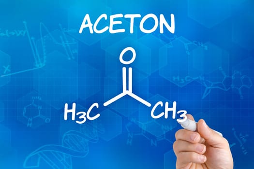 Hand with pen draws chemical structural formula of acetone