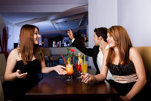 Man ordering drinks while girls having fun
