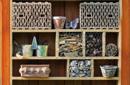 Shelf with insect hotel and garden utensils