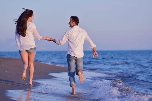 happy young romantic couple in love have fun on beautiful beach at beautiful summer day