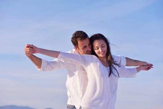 happy young romantic couple in love have fun on beautiful beach at beautiful summer day