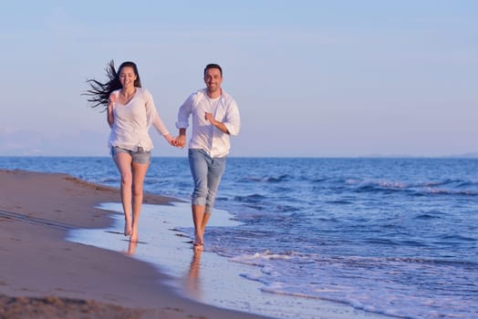 happy young romantic couple in love have fun on beautiful beach at beautiful summer day