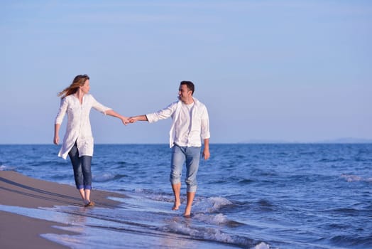 happy young romantic couple in love have fun on beautiful beach at beautiful summer day