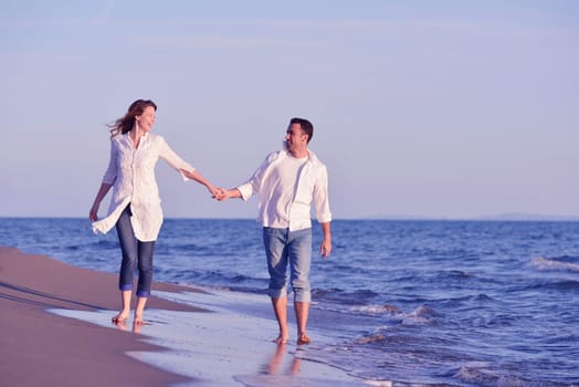 happy young romantic couple in love have fun on beautiful beach at beautiful summer day