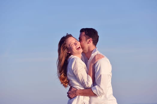 happy young romantic couple in love have fun on beautiful beach at beautiful summer day