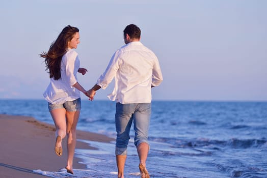happy young romantic couple in love have fun on beautiful beach at beautiful summer day