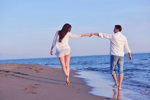 happy young romantic couple in love have fun on beautiful beach at beautiful summer day