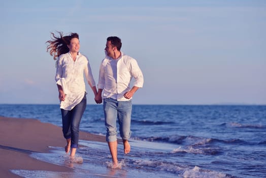 happy young romantic couple in love have fun on beautiful beach at beautiful summer day