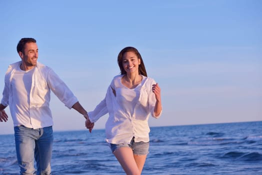 happy young romantic couple in love have fun on beautiful beach at beautiful summer day