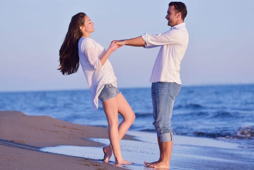 happy young romantic couple in love have fun on beautiful beach at beautiful summer day