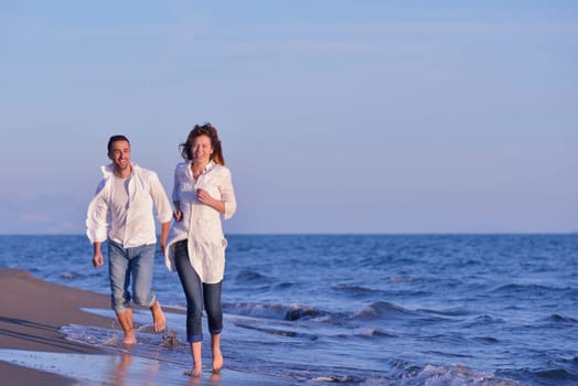 happy young romantic couple in love have fun on beautiful beach at beautiful summer day