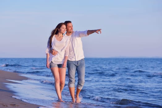 happy young romantic couple in love have fun on beautiful beach at beautiful summer day