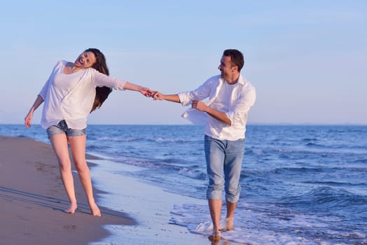 happy young romantic couple in love have fun on beautiful beach at beautiful summer day