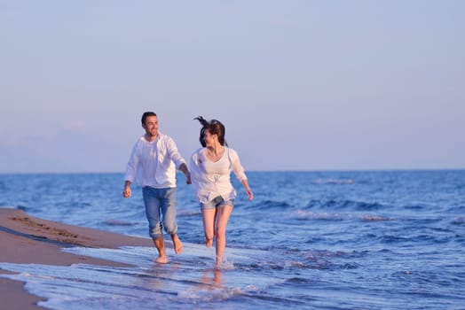 happy young romantic couple in love have fun on beautiful beach at beautiful summer day