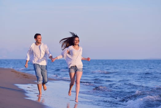 happy young romantic couple in love have fun on beautiful beach at beautiful summer day