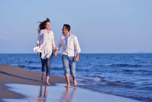 happy young romantic couple in love have fun on beautiful beach at beautiful summer day