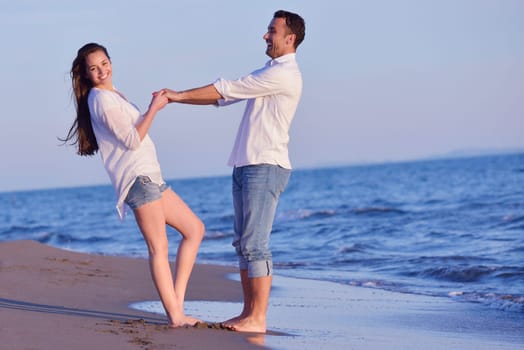 happy young romantic couple in love have fun on beautiful beach at beautiful summer day
