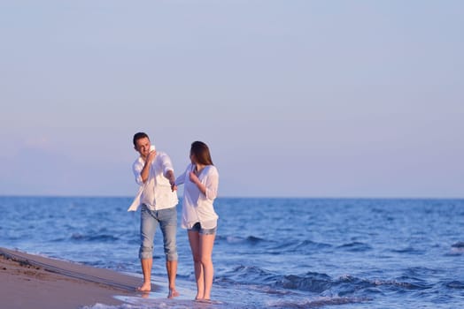 happy young romantic couple in love have fun on beautiful beach at beautiful summer day