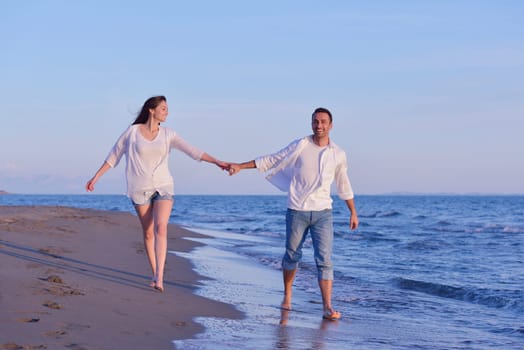 happy young romantic couple in love have fun on beautiful beach at beautiful summer day