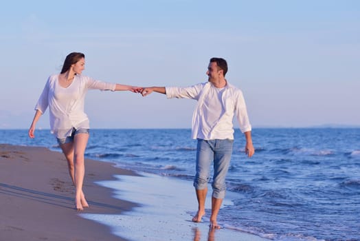 happy young romantic couple in love have fun on beautiful beach at beautiful summer day