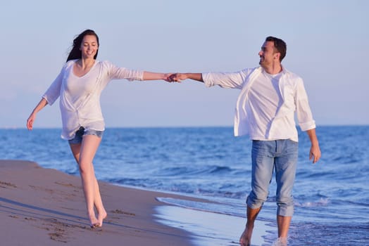 happy young romantic couple in love have fun on beautiful beach at beautiful summer day