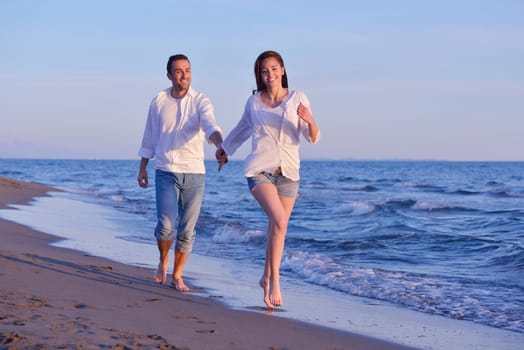 happy young romantic couple in love have fun on beautiful beach at beautiful summer day