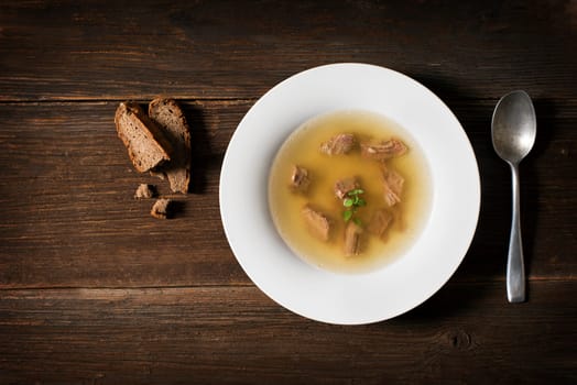 Fresh beef soup on wooden background overhead shoot