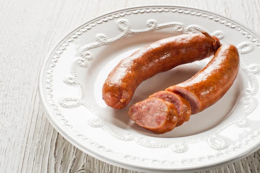 the sliced tasty sausage on a plate close up