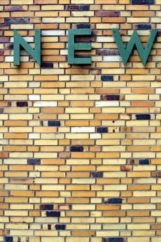 The photograph of an old and distinctive brick wall with a sign of single letters.